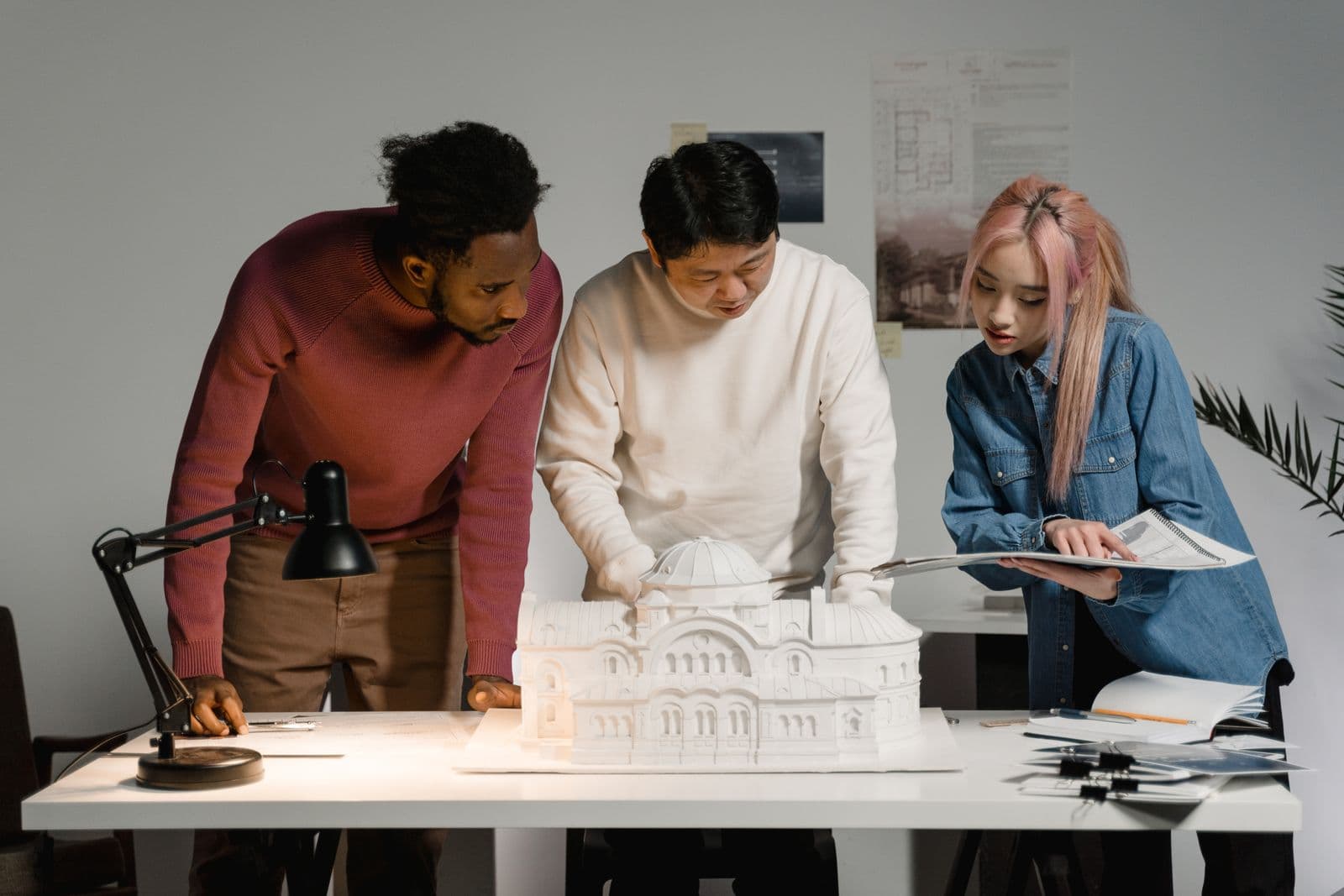 Design team reviewing ADU plans and a scale model