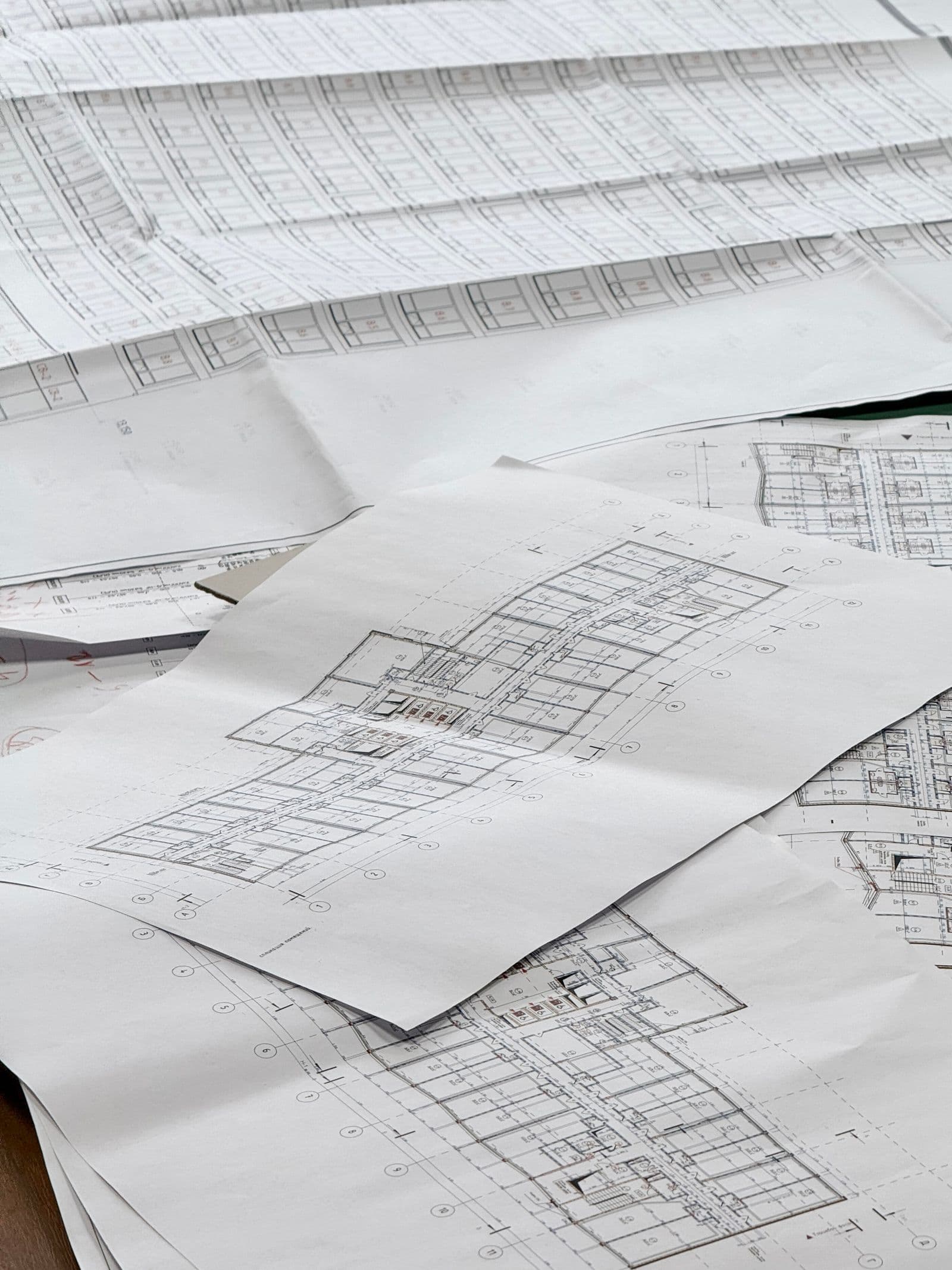 Construction plan sets spread out on a desk