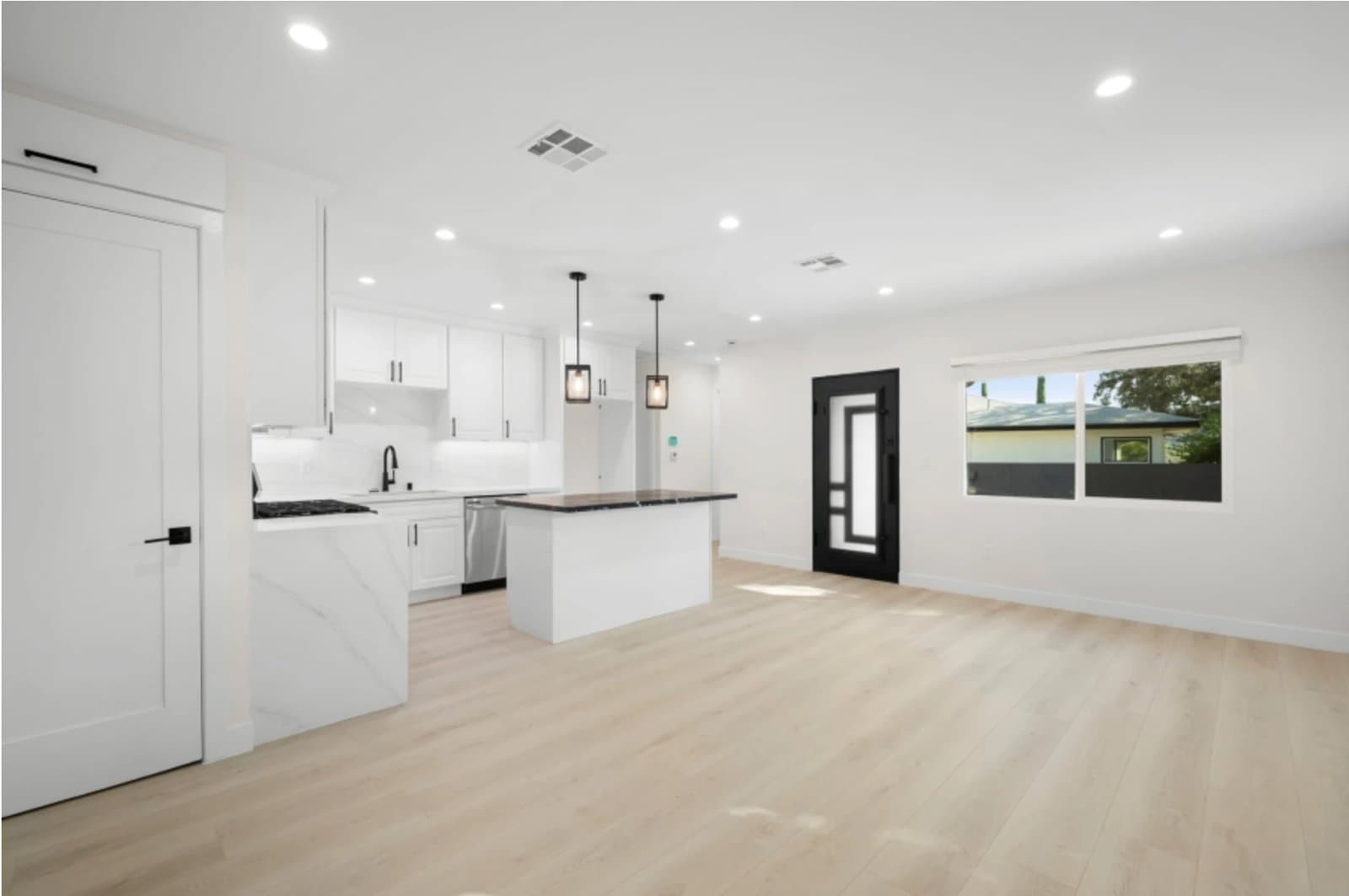 ADU living space with private black front door and open kitchen