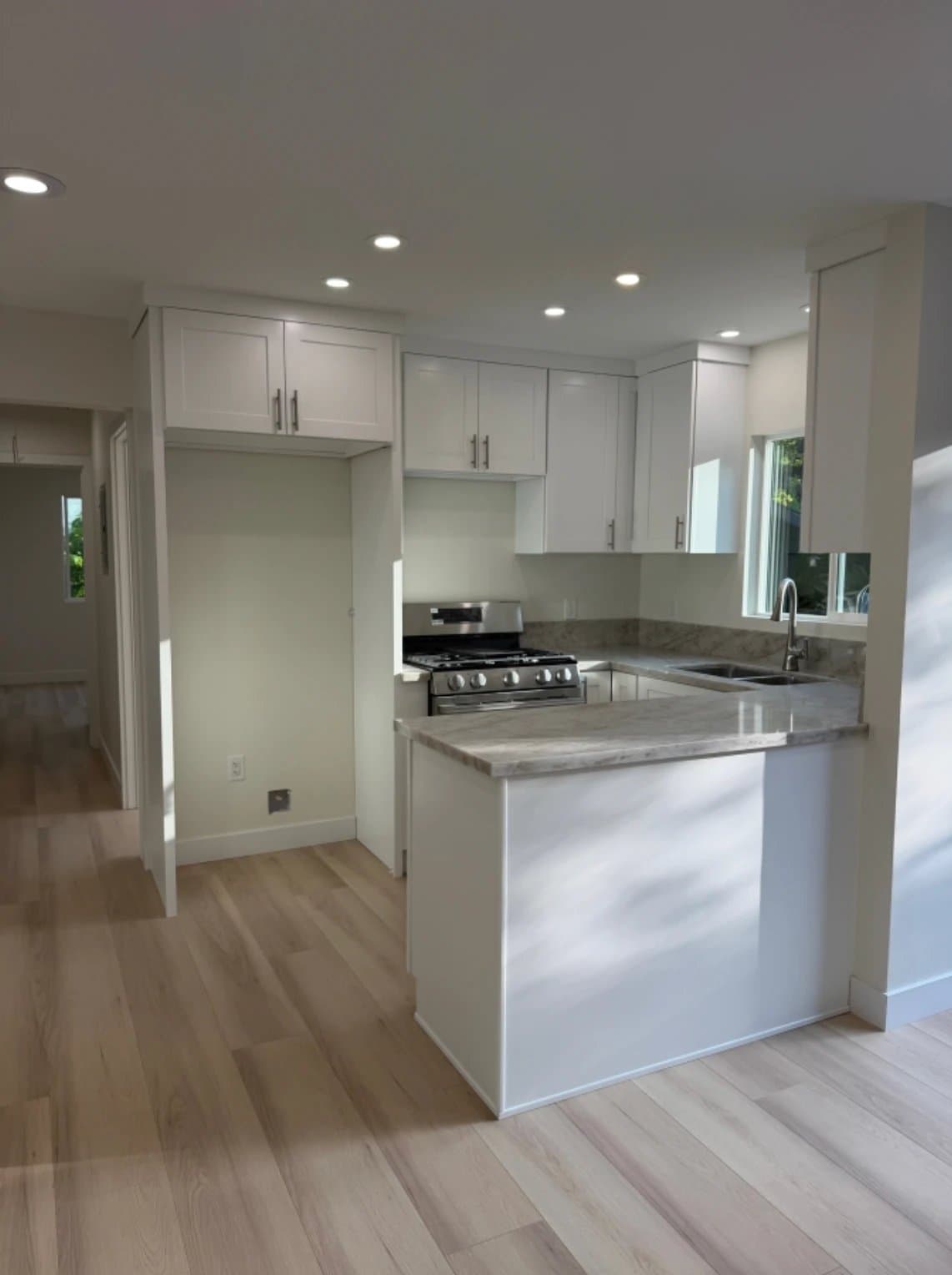 ADU kitchen with white shaker cabinets and granite counters
